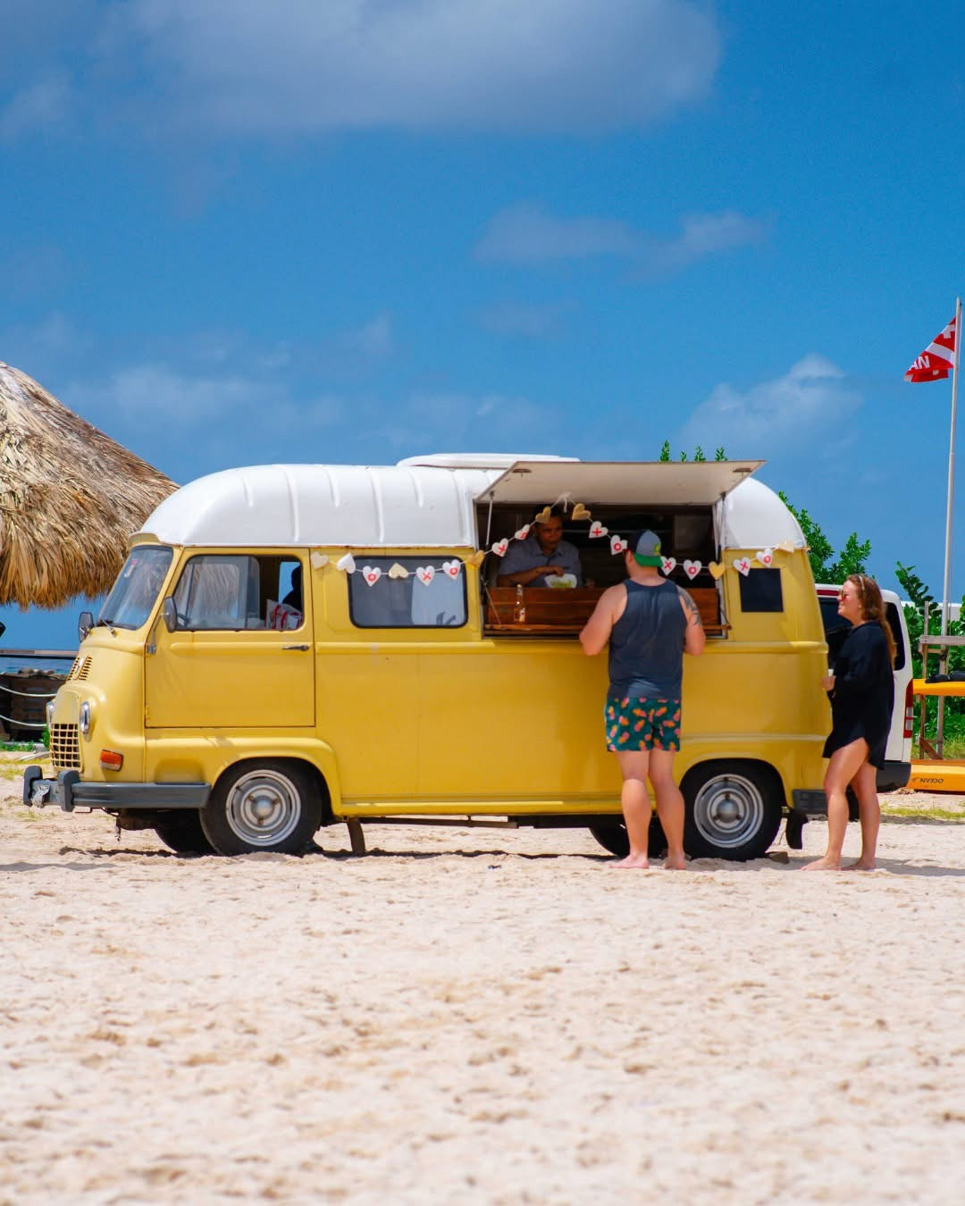 A small food van serving customers on a Curaçao beach